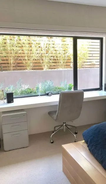 Kalın pencere pervazı yüzen masa olarak kullanılmış, küçük çekmeceli dolap alanı düzenli tutuyor.