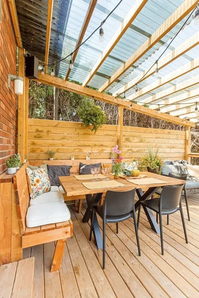 Pergola, yağmurdan korumak için polikarbonatla kaplanmış, ancak güneş ışığını geçiriyor.