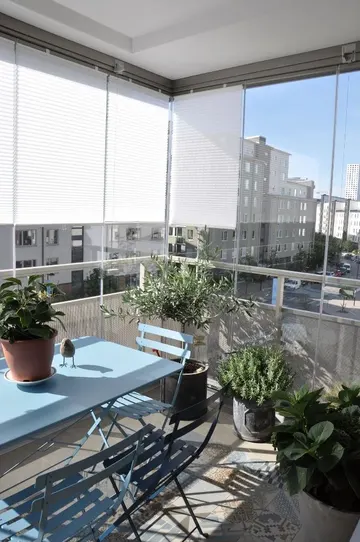 Bu balkon, saksı bitkileriyle çevrili ve güneş ışığıyla dolu açık hava yemek odasına dönüştürülmüş.