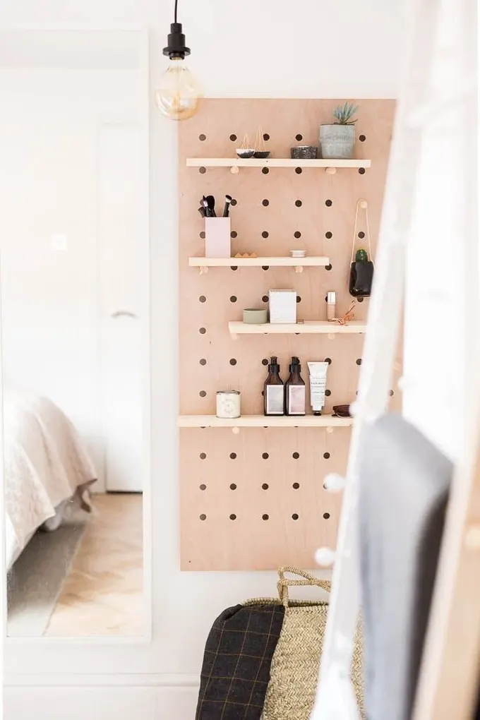 Kenarlıkları olan lekeli bir pegboard, İskandinav veya Japandi tarzı bir banyo için ideal görünüyor.