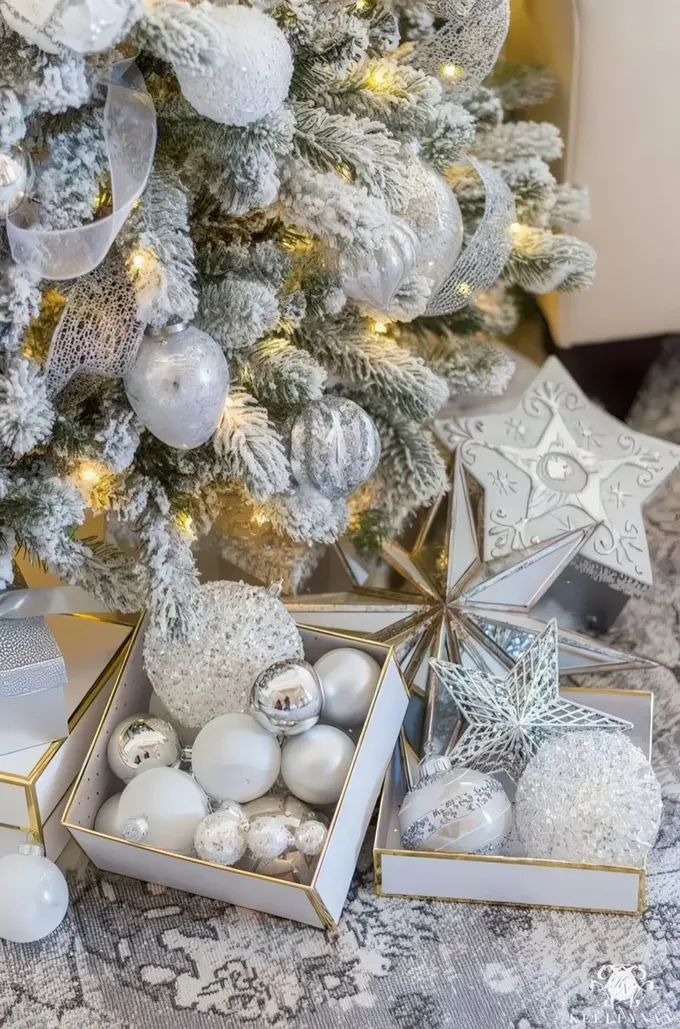 Karla kaplı, gümüş ve gümüş simli süsler ve ışıklarla donatılmış karla süslenmiş Noel ağacı, kış peri masalı havası yaratıyor.