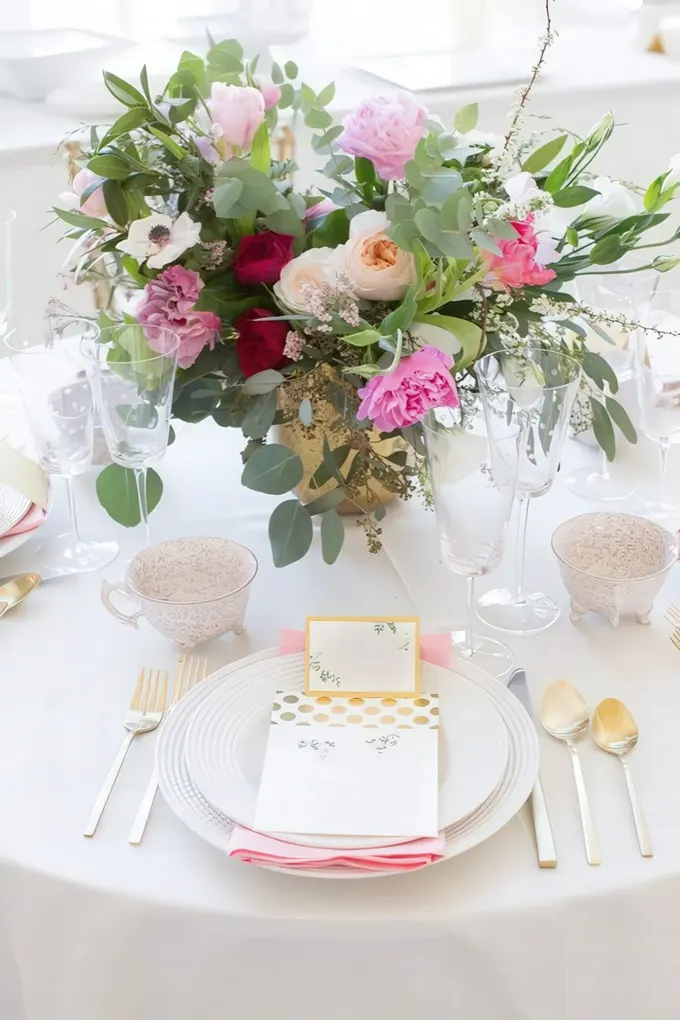 Gür çiçek aranjmanı, altın çatal-kaşık, şeftali tonlarında peçete ve isim kartı—şık, romantik baby shower masası.
