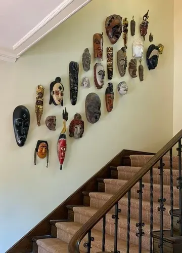 Etnik maskelerden oluşan galeri duvarı, evinize gezgin bir hava katmanın harika bir yolu.