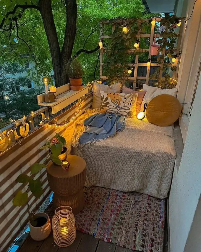 Balkon, oturma alanının üzerindeki ışık dizisi ampulleri ve birkaç mum feneriyle aydınlatılmış.