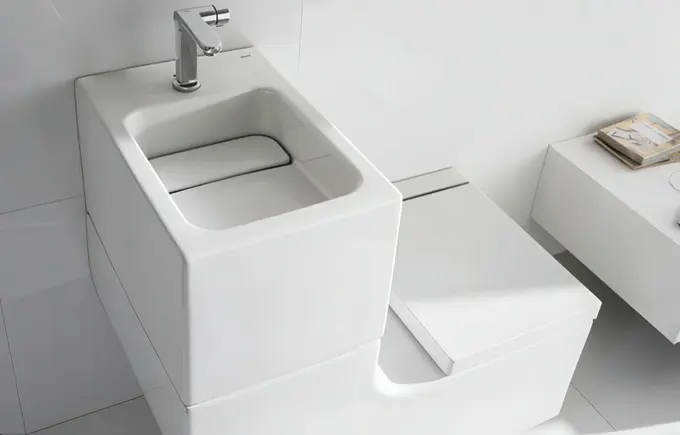 Şık beyaz kavisli lavabo ve tuvalet kombini.