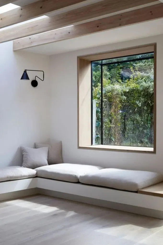 Bu kutu pencere manzaranın keyfini çıkarmayı sağlar ve minimalist odaya ilgi katıyor.