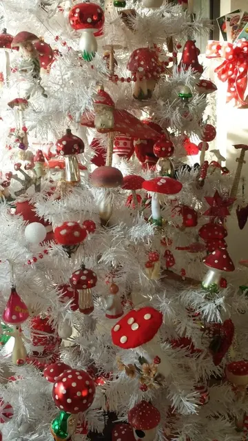 Beyaz bir Noel ağacında kırmızı mantarlar hemen göze çarpar ve masalsı bir atmosfer oluşturur.