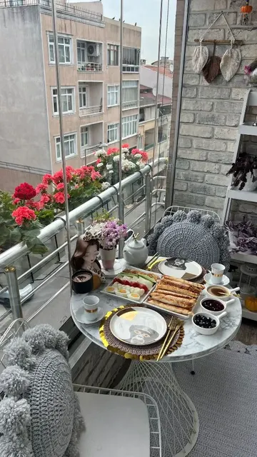 Bu küçük balkon, metal mobilyalar, bohem dekor ve bitkilerle dolu tam bir yemek alanı.