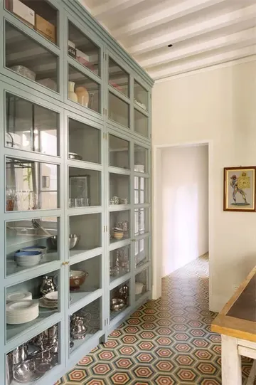 Cam kapaklı büyük mavi dolap, tüm masa ve pişirme gereçlerini saklamak için harika bir fikir.