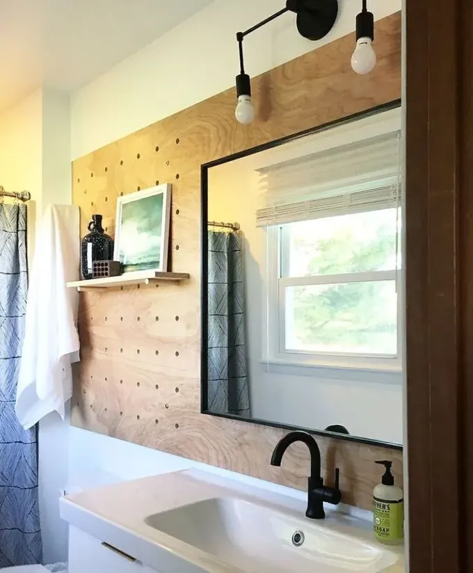 Raf ve aynalı boyalı pegboard, modern banyo için hoş bir fikir; siyah detaylarla vurgulayın.