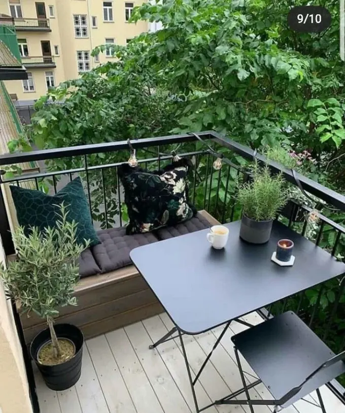 Balkon siyah katlanabilir mobilyalara yeterince geniş, saklama bankı dağınıklığı gizliyor.