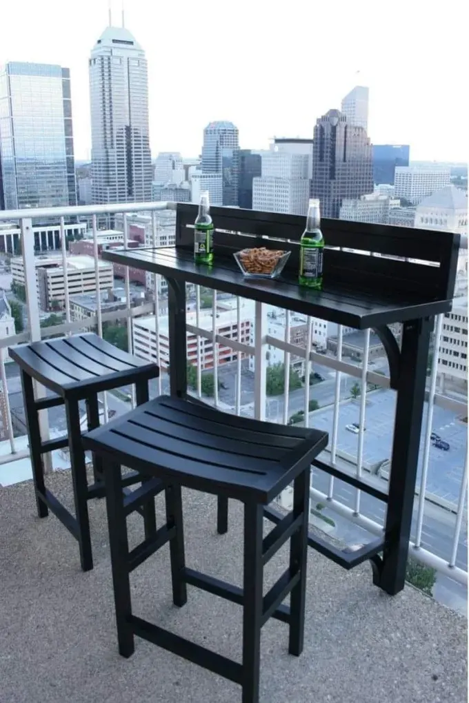 Balkon, ince yüksek masa ve uyumlu birkaç tabureye sahip.