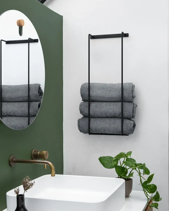 Minimalist ama soğuk değil. Siyah çerçeve ve düzgün rulo yapılmış havlular, banyonuzu butik otel havası verir... aslında çerçevenin dışında her şey dağınıksa bile..