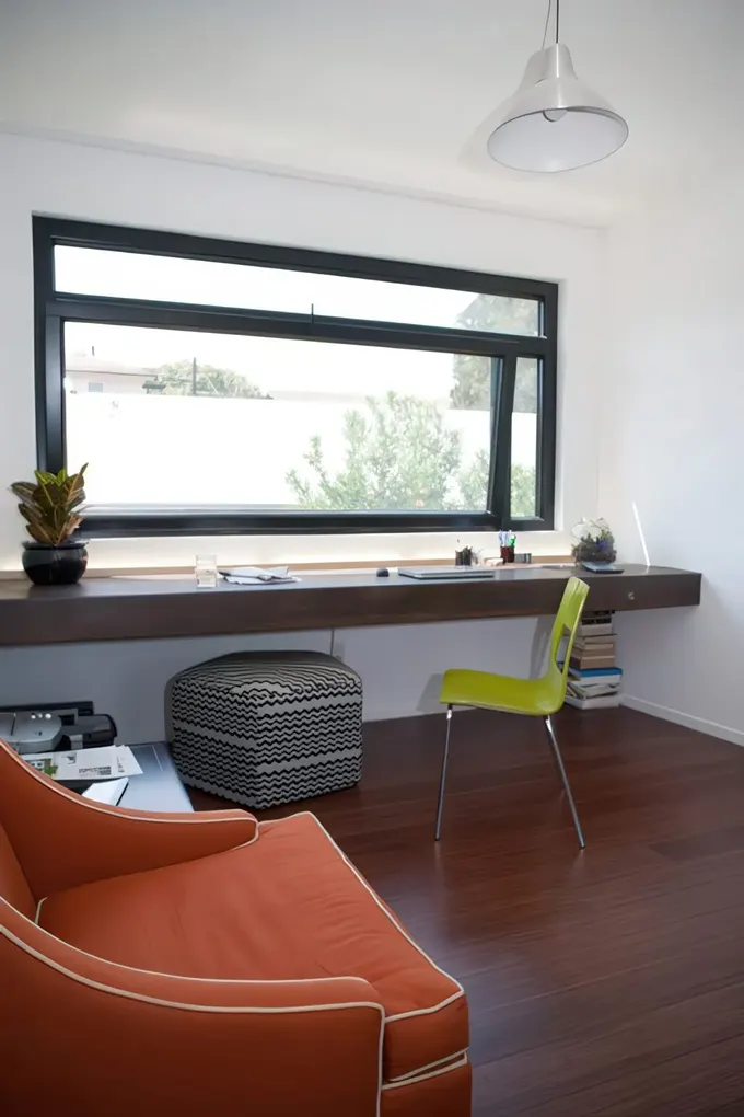 Modern siyah çerçeveli pencere ve kalın ahşap pencere pervazı masası şık bir sandalye ile tamamlanmış.