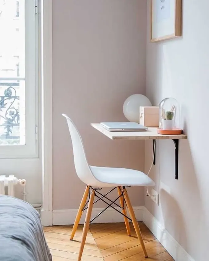 Kompakt alanda uzaktan çalışma için ideal minimalist yatak odası ofis düzeni. Asma masa ve İskandinav tarzı sandalye, fonksiyonelliği artırırken odaya uyum sağlar.