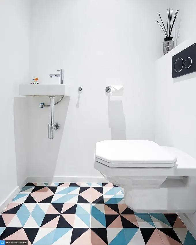 Minimalist tasarım, yumuşak mavi, siyah ve pembe desenli fayanslarla cesur bir dokunuş kazanıyor. Düz beyaz duvarlar ferah bir his verirken, asma klozet ve kompakt lavabo temiz estetiği destekliyor. Bazen gerçek yıldız zemin olur.
