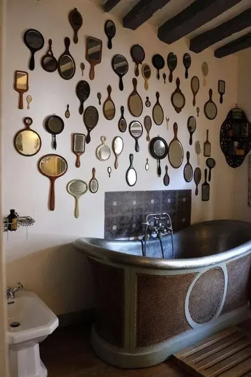 Vintage elde tutulan aynalardan oluşan galeri duvarı, şık bir banyoya harika bir dokunuş sağlar.