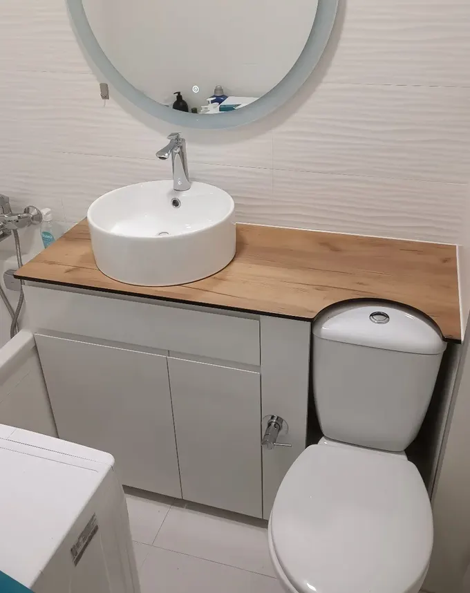 Fonksiyonel tasarımlı bu banyoda, tezgah üstü lavabo ve altında gizli depolama dolabı ile küçük daire banyolarına şık ve pratik çözüm sunuluyor.