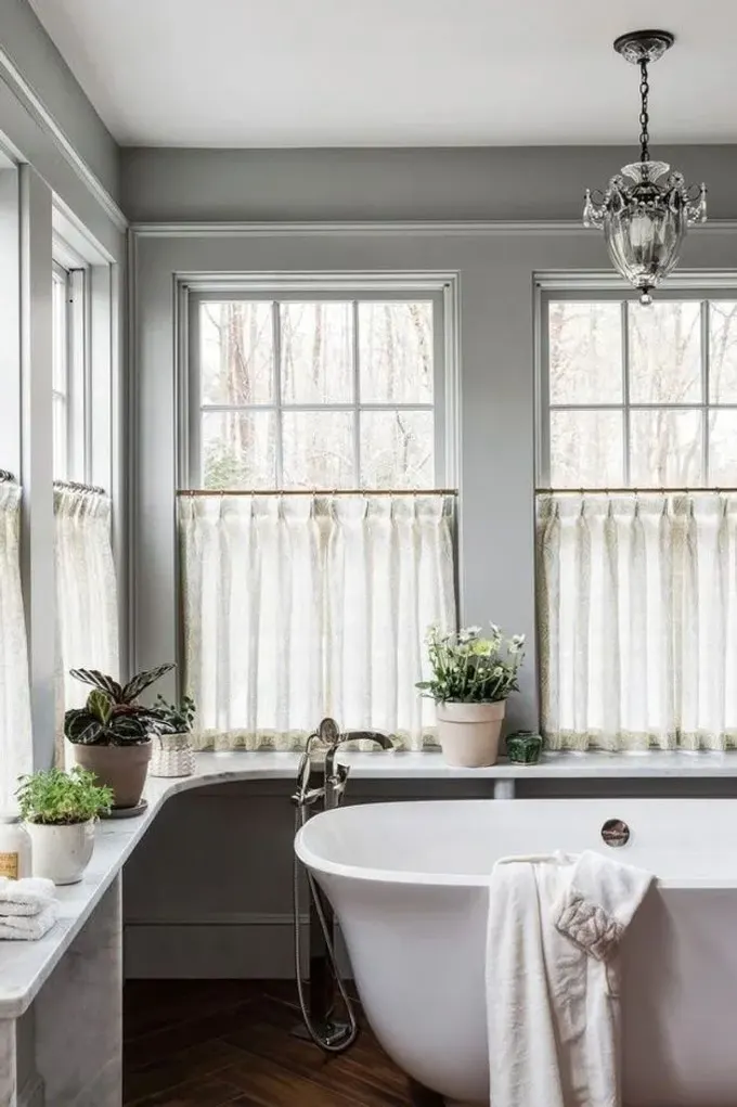 Banyo, mahremiyet için cafe perdelerle kaplı bir pencere düzenine sahip, ama ışık yeterli.