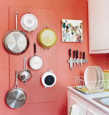 Mercan renkli vurgu duvar, pegboard ve manyetik raf ile yapılmış.