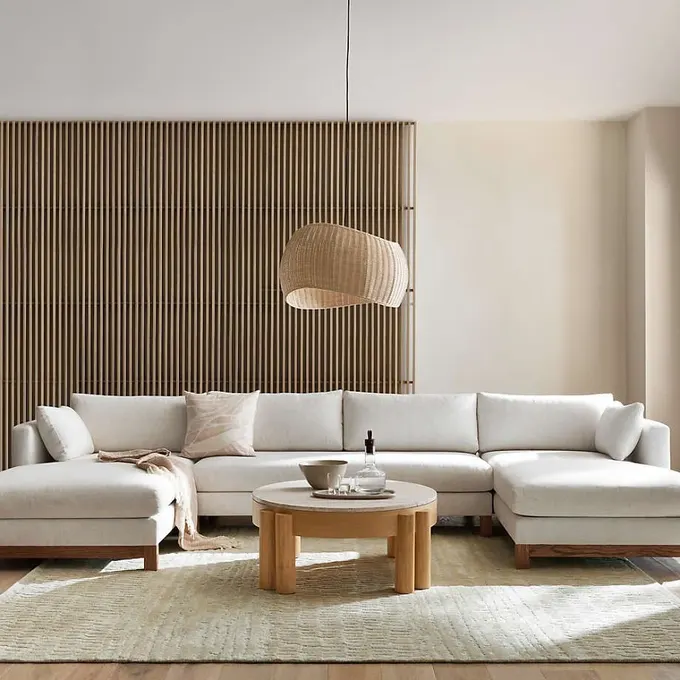 Krem rengi slipcover ve ahşap ayaklı köşe kanepe, zamansız ve birçok mekâna uyumlu klasik bir parça.
