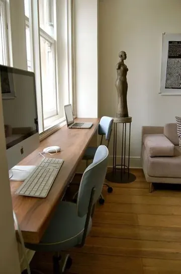 Bu şık boyalı pencere pervazı, iki kişi için ortak bir masa ve uyumlu sandalyelerle mekana bütünlük katıyor.