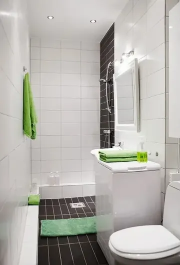 Beyaz ve kahverengi çikolata tonlarında sade, parlak yeşil vurgularla çağdaş banyo.