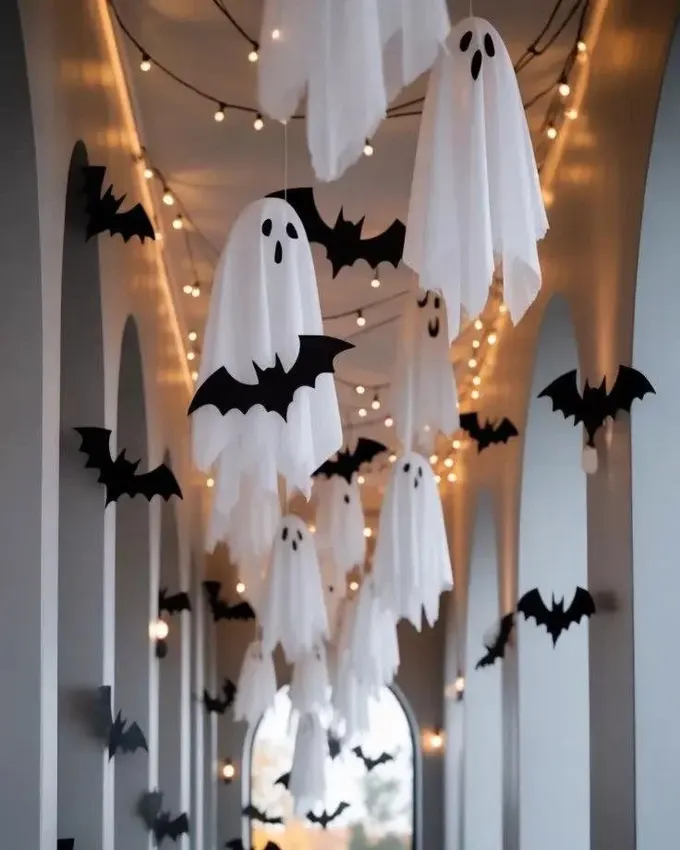 Asma kumaş hayaletler, siyah kağıt yarasalar ve ışık zincirleri ile kendin yap Halloween tavan süsleri; şenlikli ve gizemli bir koridor için.