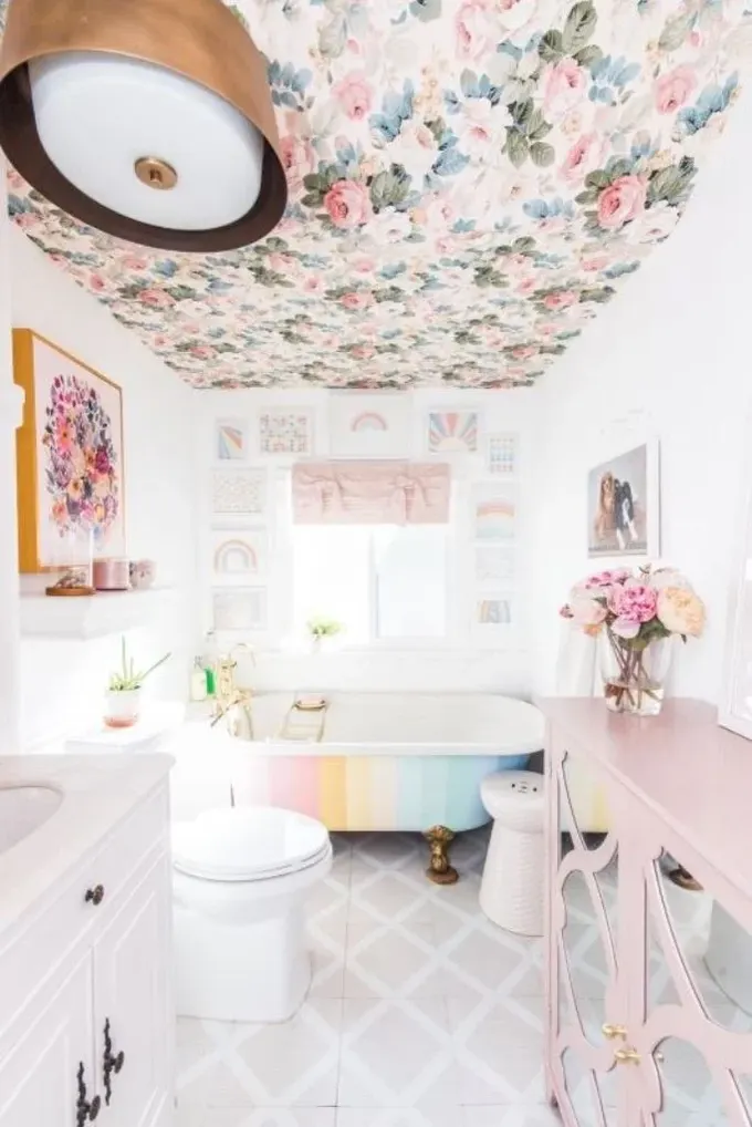Banyo, çiçekli tavan, şeftali renkli dolap ve pastel gökkuşağı küvetiyle pastel tonlarla canlandırılmış.