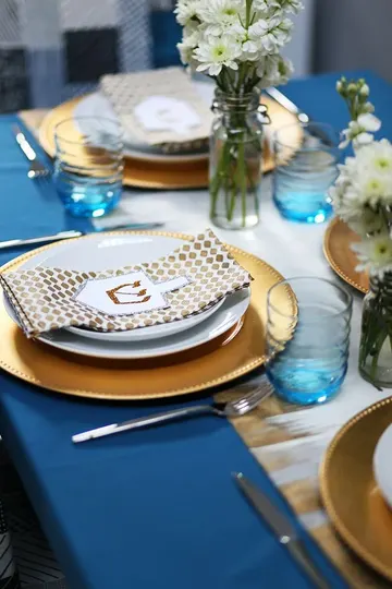 Mavi, klasik bir Hanuka rengi; masayı daha çarpıcı yapmak için beyaz kontrast ve şıklık için altın ekleyebilirsiniz.