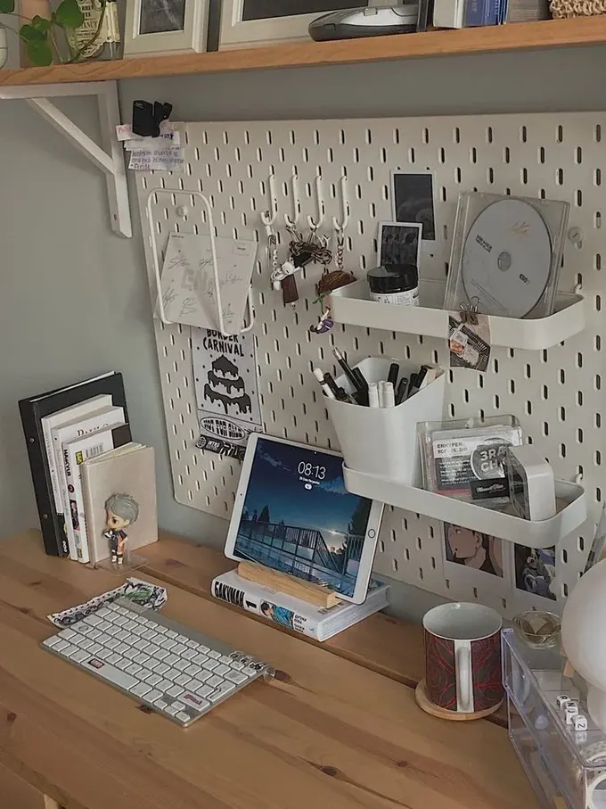 Küçük çalışma alanına dikey depolama eklemek şart; burada dekor için bir raf ve işlevsellik için pegboard eklenmiş.