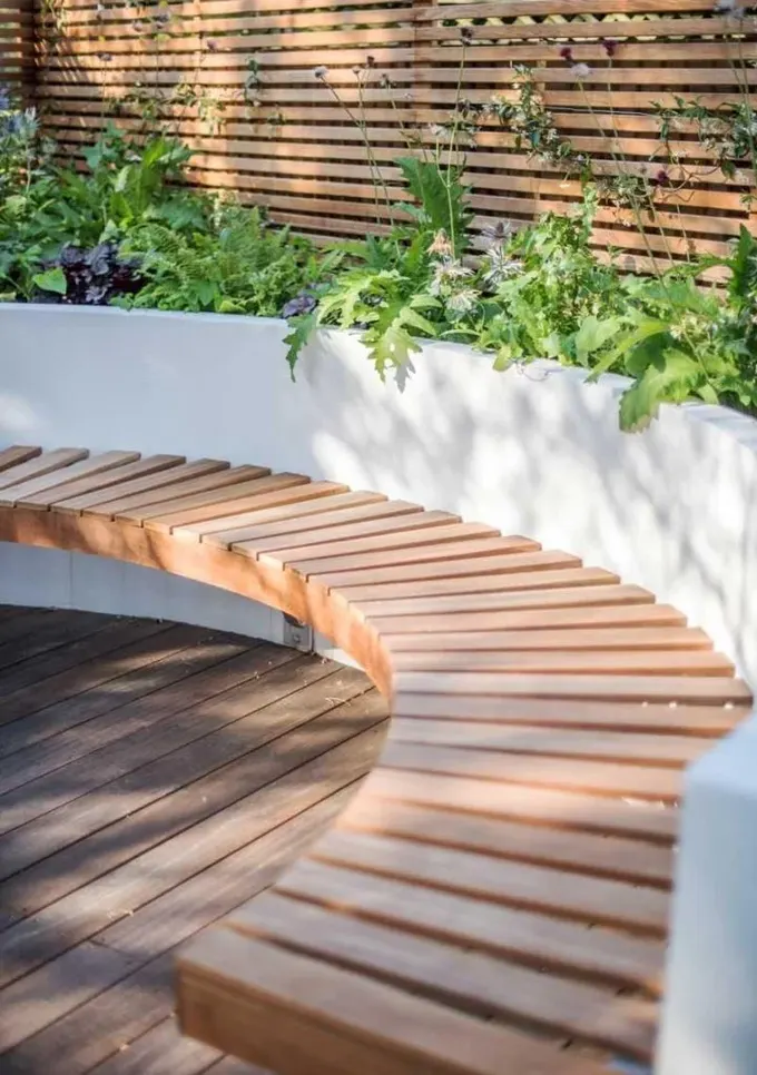 Modern veranda, yükseltilmiş bahçe yatağı ve buna bağlı asma bank ile tasarlanmış.