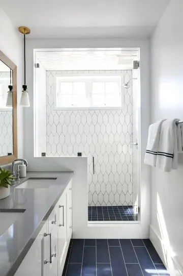 Modern kıyı stili banyo, lacivert ve beyaz fayanslar, duşta pony duvar ve beyaz lavabo ünitesi.