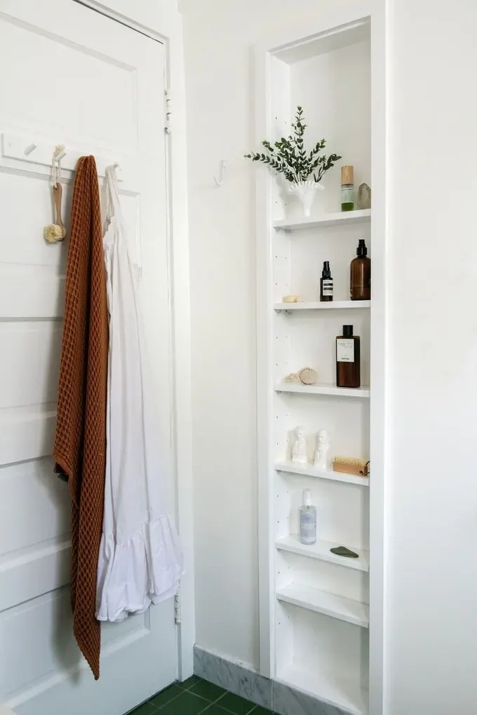 Kapıdaki banyo askılığı, havlu ve bornozlar için klasik, arkasındaki küçük niş ise ekstra depolama sunar.