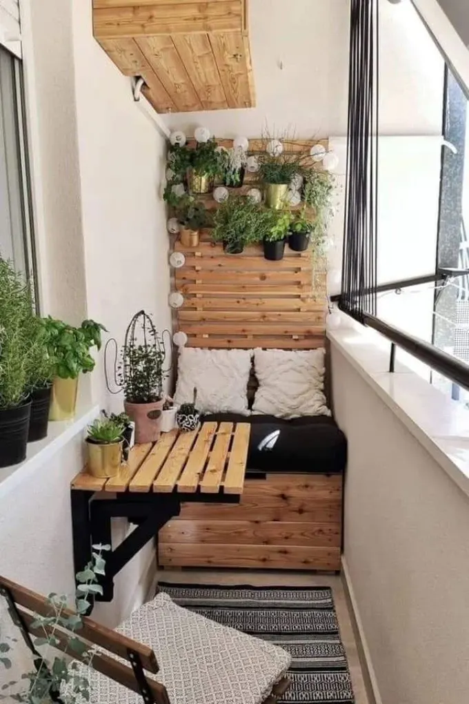 Dar alanda boyalı mobilyalar ve duvara monte masa kullanılmış, çok sayıda saksı bitkisi doğa hissi yaratıyor.