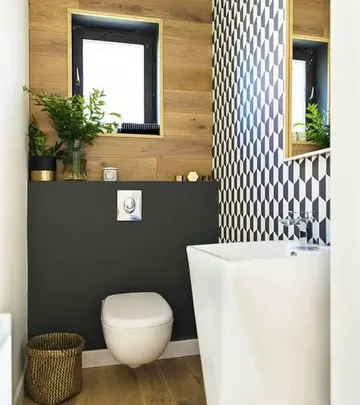 Geometrik duvar, bağımsız lavabo, kontrplak ve mat siyah duvar ile siyah çerçeveli pencere içeren şık misafir tuvaleti.