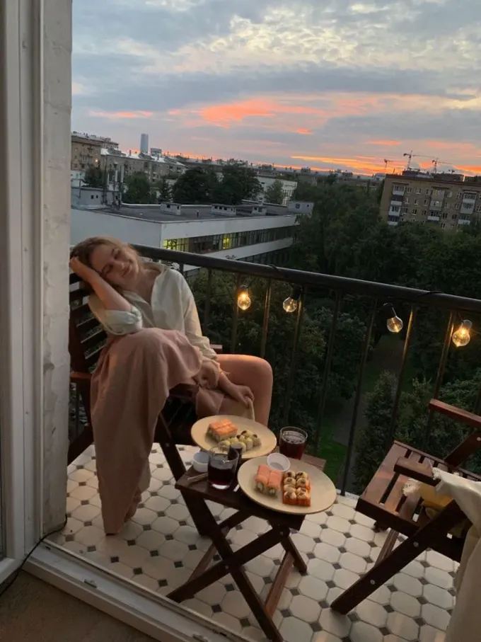 Balkon, IKEA'nın koyu renk katlanabilir mobilyaları ve ampullerle atmosfer yaratacak şekilde dekore edilmiş.