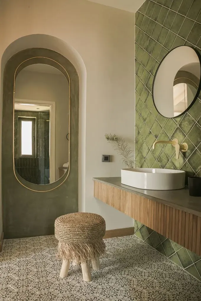 Yüzen lavabo, ahşap levhalarla dokulu hale getirilmiş; püsküllü jüt puf ise evin kıyı konumunu vurguluyor.