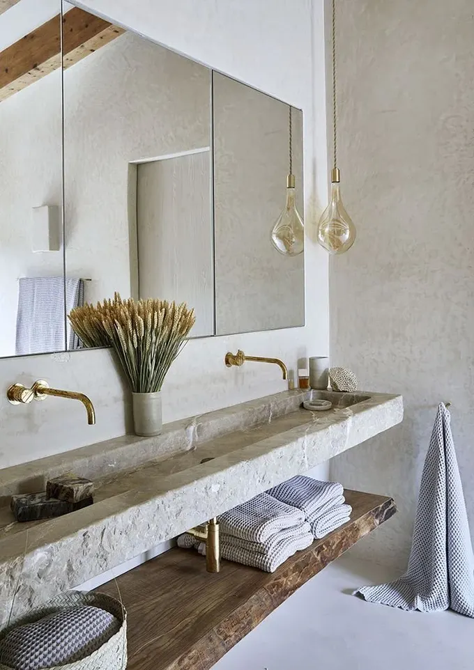 Bu yüzen lavabo, taştan çift lavabo ve doğal kenarlı, canlı kenarlı ahşap rafıyla dikkat çekiyor.