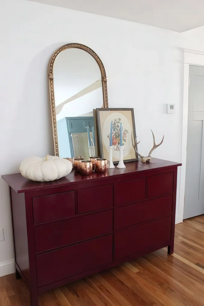 Antler ve kabakla süslenmiş, sonbahar için bordo boyalı vintage tarzı konsol.