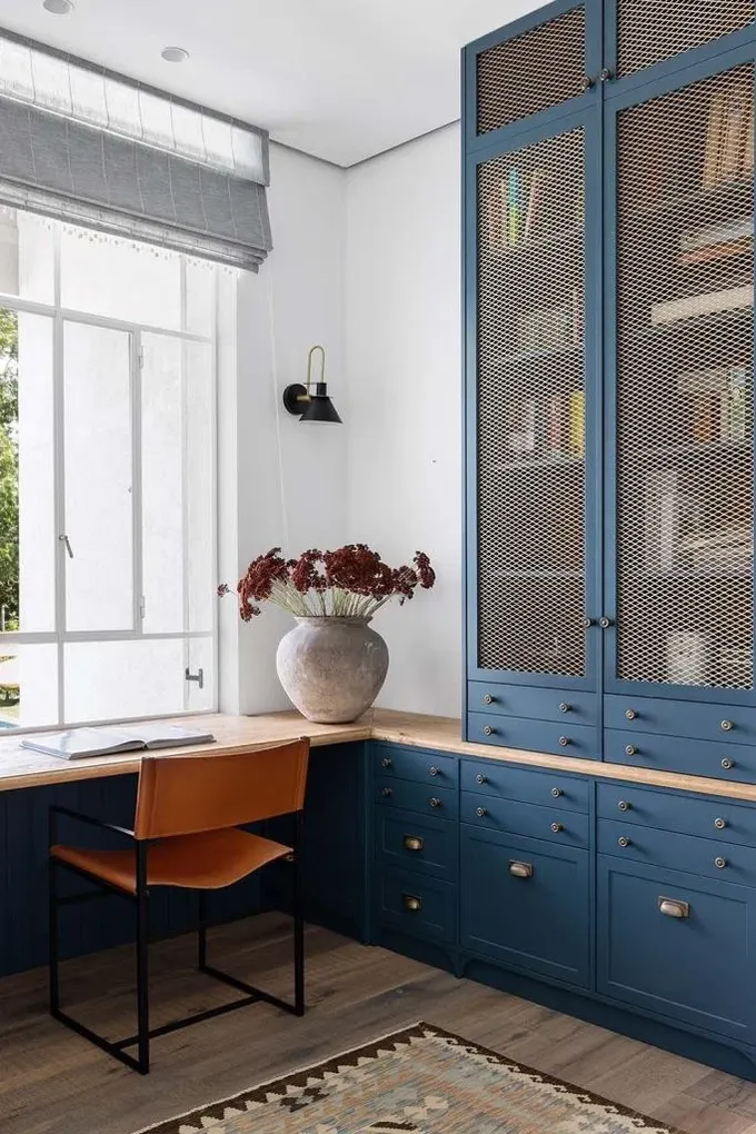 Bu pencere pervazı kitaplığa entegre edilmiş, elegant lacivert ve kehribar renkler kullanılmış.