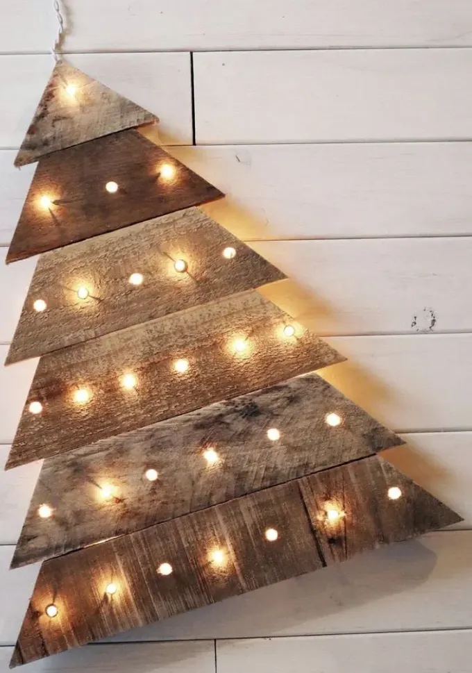 İç ve dış mekan için palet ve entegre ışıklardan yapılmış, basit ve şık bir Noel ağacı dekoru.