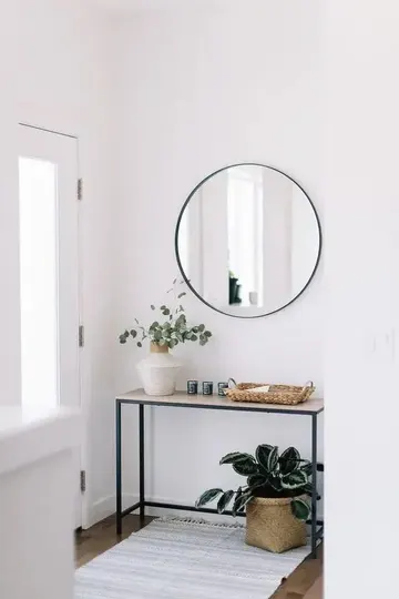 Yeşillikli vazo, hasır sepet ve konsol altında saksı planterli minimal konsol masa.