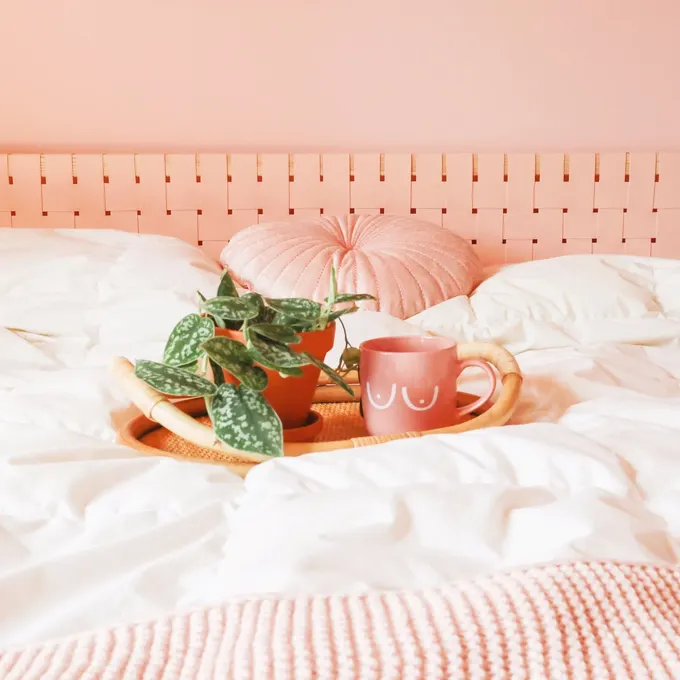 IKEA Malm yatak başlığını dokulu pembe kumaşla tamir edin, yumuşak ve feminen bir hava katın. Bu ev yapımı çalışma odaya doku ekler.