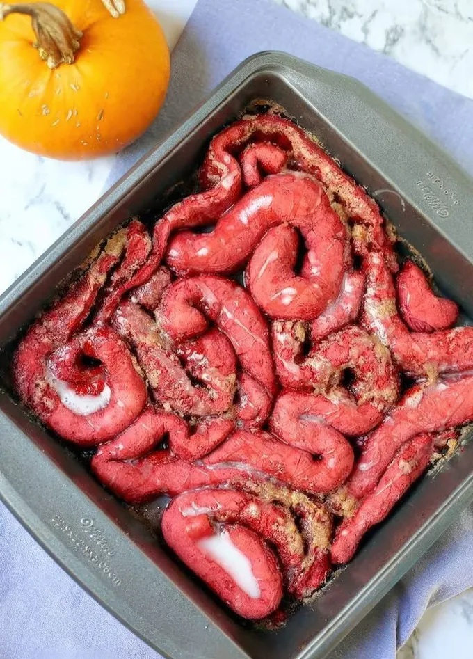 Karamel ve kremalı kırmızı kadife tarçınlı rulolar, Cadılar Bayramı için harika ve oldukça korkutucu.