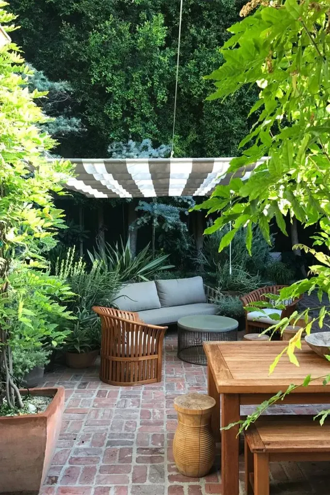 Pergola, terasa ilgi ve görsellik katan çizgili bir örtü ile yapılmış.