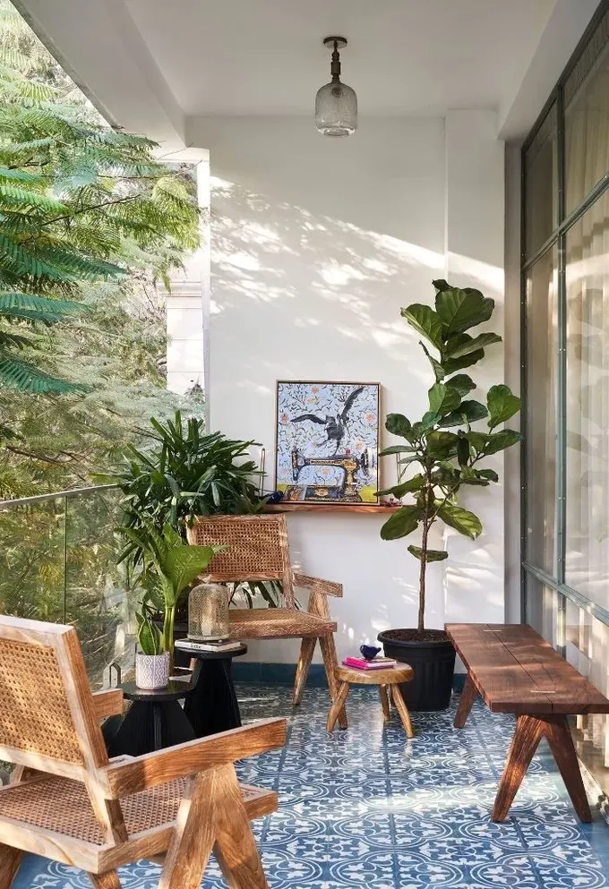 Balkon, cesur mavi Fas karoları, kamış ve ahşap mobilyalar ile saksı bitkilerinden oluşuyor.