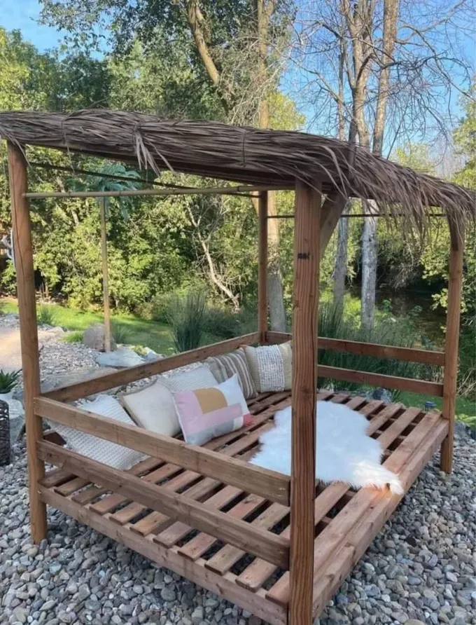 Büyük boyalı pergola, yastıklı bir güneşlenme yatağı; havuz alanı için harika bir fikir.
