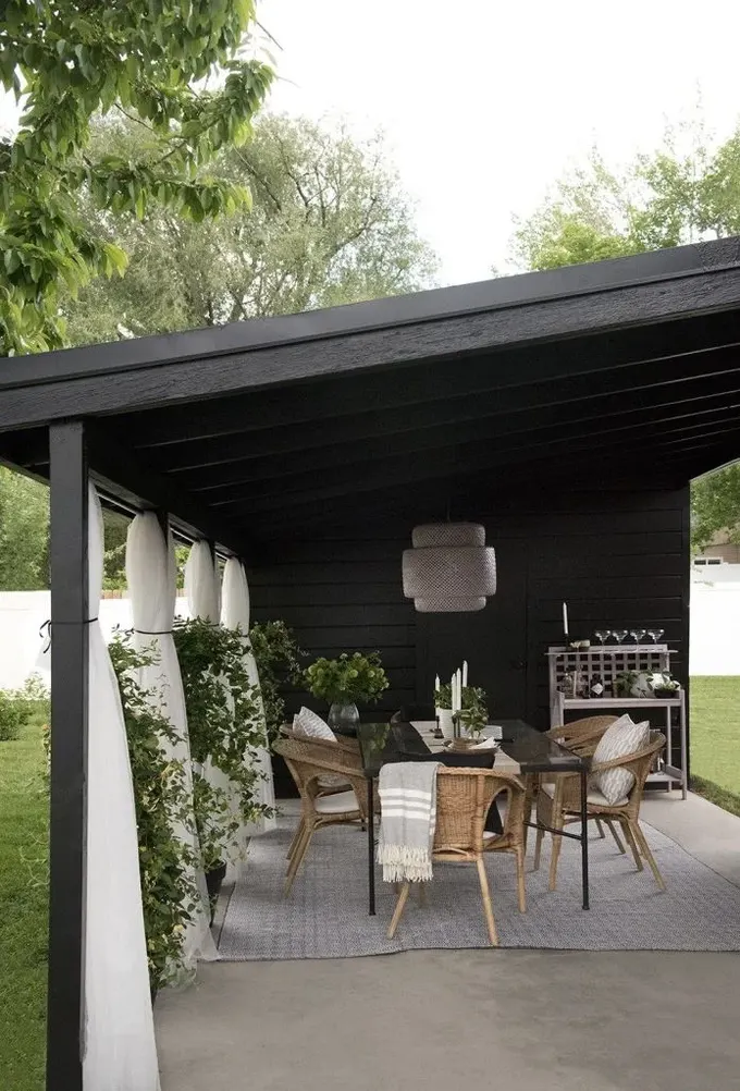 Siyah pergola, her şeyi iyi koruyan klasik bir çatıya sahip.