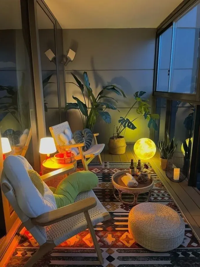 Balkon, şık modern mobilyalar, bitkiler ve iç mekan lambasına benzeyen bir lamba ile ay şeklinde LED ışıkla dekore edilmiş.